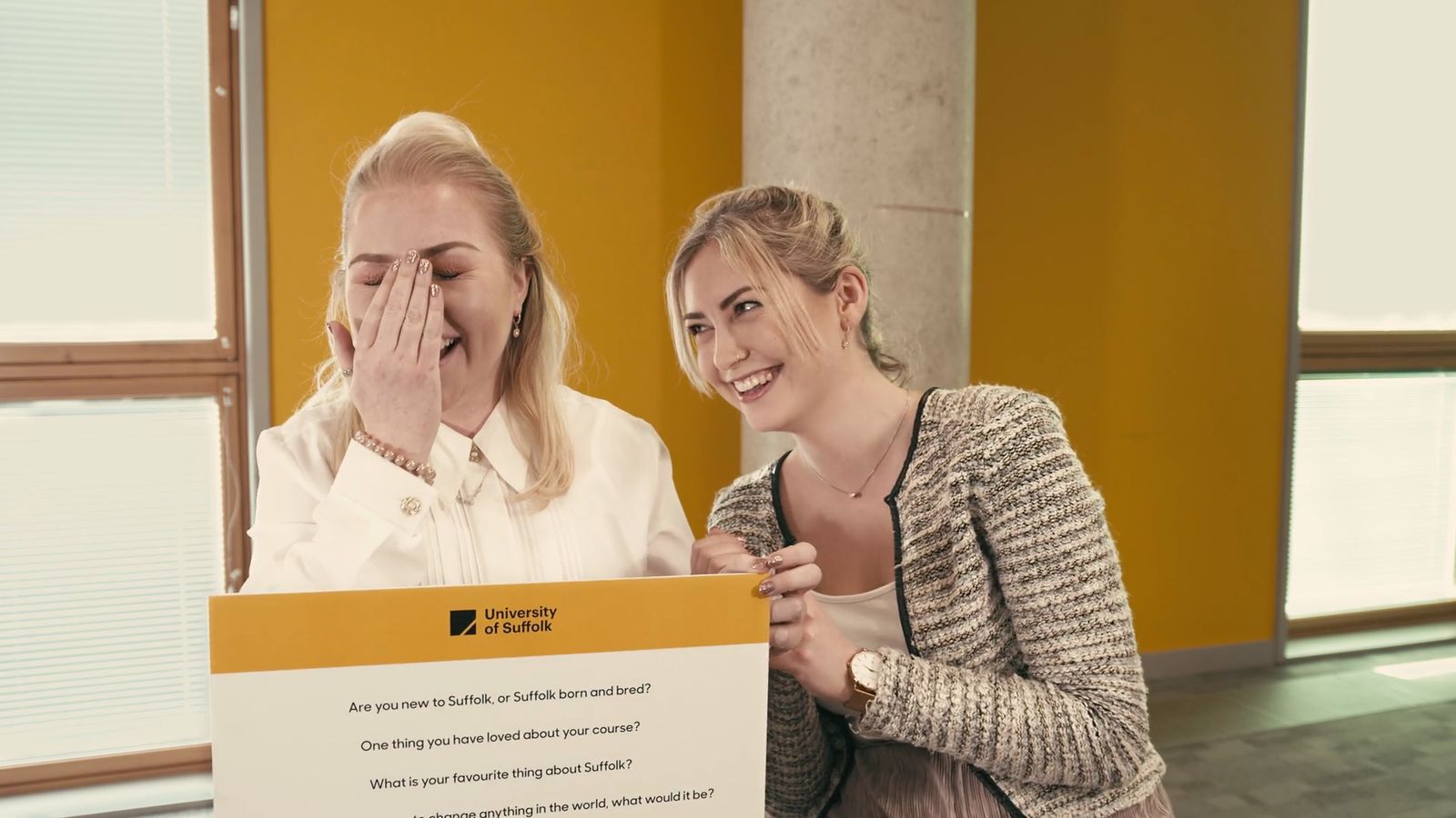 Two students laughing on campus at the University of Suffolk